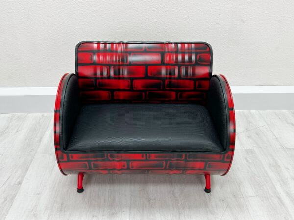 Sofa aus Oelfass im Backstein-Design von Vorne mit schwarzer Polsterung und schwarzem Kantenschutz auf weißem Holzboden vor weißer Wand