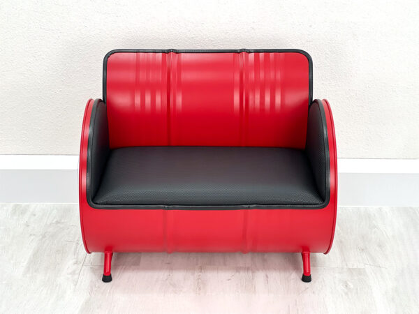 Sofa aus Oelfass in Rot von Vorne mit schwarzer Polsterung und schwarzem Kantenschutz auf weißem Holzboden vor weißer Wand