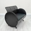 2er Sofa in Schwarz aus Oelfass mit schwarzer Polsterung, halbseitliche Ansicht, auf weißem Holzboden vor weißer Wand