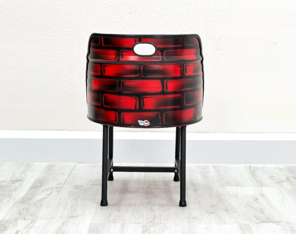 Oelfass Esszimmer Stuhl in Rot mit aufgesprayten Backsteinen auf der Rückseite, mit schwarzem Sitzpolster und schwarzen Metallbeinen auf weißem Holzboden vor weißem Hintergrund