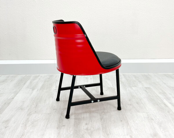 Seitliche Ansicht von Oelfass Esszimmer Stuhl LIAM in Rot mit schwarzen Metallbeinen auf weißem Holzboden vor weißem Hintergrund