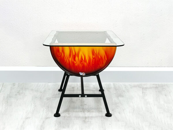 Frontalansicht von Tisch Mick mit Glastischplatte im Flammendesign auf schwarzen Beinen vor weißer Wand auf weißem Holzboden