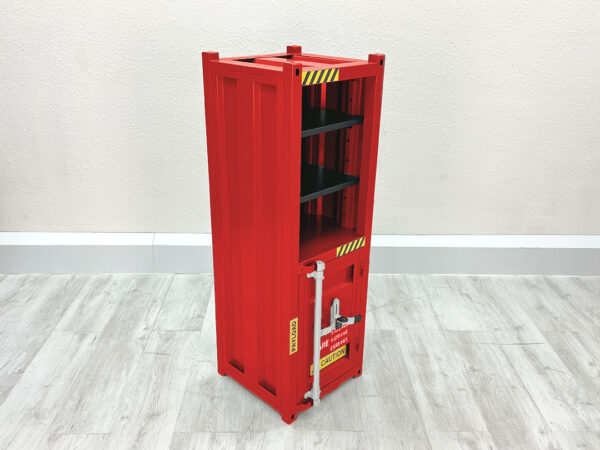 Roter Regalschrank aus Metall in Uebersee Container Optik, untere Haelfte mit Tuer verschlossen, stehend auf weißem Holzboden vor weißer Wand