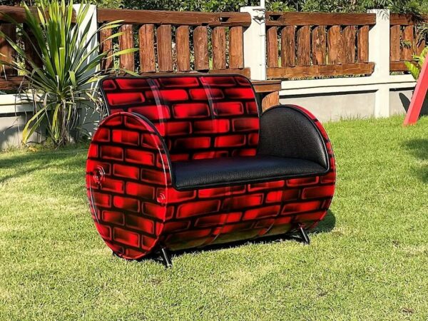 Seitenansicht des eleganten Oelfass Upcycling Sofas "Carla" in einer beeindruckenden Backstein Optik in Schwarz-Rot, veredelt mit hochwertigem Kunstleder Bezug - Tonnen Tumult