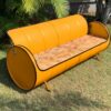 Unser Sofa Joy in strahlendem Gelb, präsentiert vor einer neutralen Wand