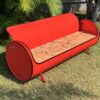 Rot Sofa 'Joy' von Tonnen Tumult, geschickt upcycelt aus einem Oelfass und stilvoll platziert in einem Wohnzimmer.