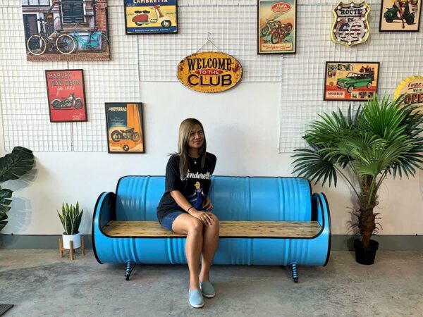 Frau sitzt auf hellblauem Ölfass Sofa 'Joy' von Tonnen Tumult