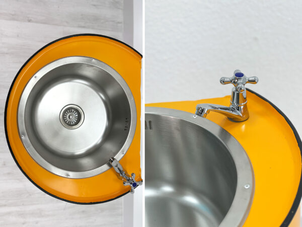 Detailaufnahme von Spueltisch Lia in Gelb - Edelstahlspuehlbecken mit Wasserhahn vor weißem Hintergrund